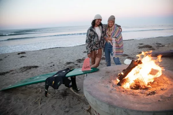 Couple around fire pit at the beach